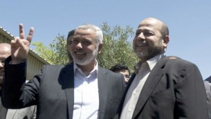 رئيس الوزراء الفلسطيني في قطاع غزة إسماعيل هنية يحيي نائب زعيم الحركة، موسى أبو مرزوق، لدى وصوله مدينة غزة، الاثنين 21 أبريل، 2014 (تصوير: AFP PHOTO / محمود الهمص) 