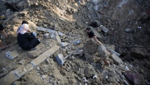 فلسطيني يحمل قطعة اثاث من بين حطام بيت اصيب بالغارة على بيت حانون بحسب مصادر اسرائيلية ٩ يوليو ٢٠١٤ (محمد عبد/ أ ف ب)