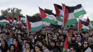 الالاف من مواطني اسرائيل العرب يحملون الأعلام الفلسطينية خلال مسيرة العودة السنوية من اجل حق العودة للاجئين الفلسطينيين الذين فروا من ديارهم أو طردوا خلال حرب عام 1948. مسيرة هذا العام الى قرية الحدثة بالقرب من طبريا في شمال إسرائيل، 23 أبريل عام 2015. AFP PHOTO / AHMAD GHARABLI