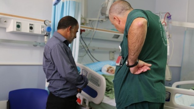 حسين دوابشة وطبيب بجانب سرير احمد دوابشة  (Eric Cortellessa/Times of Israel)