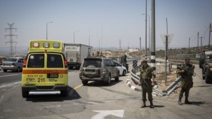سيارة إسعاف تقوم بإجلاء رجل فلسطيني أُصيب بجراح طفيفة بعد تعرضه لإطلاق النار بعد طعنه لجندي إسرائيلي في حاجز "بل"، على طريق رقم 443، 15 أغسطس، 2015. (Hadas Parush/Flash90) 