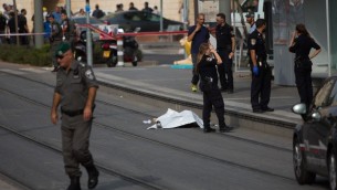 الشرطة بالقرب من جثمان منفذ هجوم طعن فلسطيني يبلغ 15 عاما في مكان وقوع الهجوم في حي بسغات زئيف شمال القدس، 12 اكتوبر 2015 (Yonatan Sindel/Flash90)