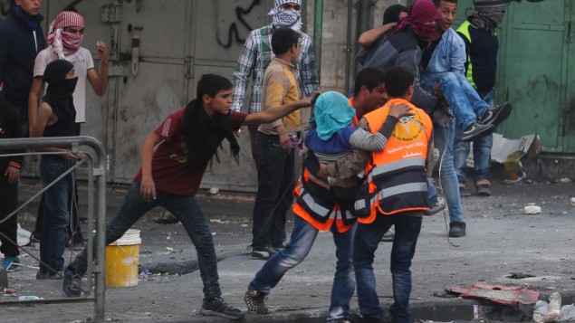 مسعفون فلسطينيون يحملون رجل مصاب خلال اشتباكات مع جنود اسرائيليين في الخليل، 31 اكتوبر 2015 (Flash90)