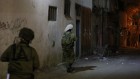 جنود يتقدمون نحو منزل مراهقين فلسطينيين اثنين يعتقد انهما شاركا في مظاهرات عنيفة في قلقيلية. يرافق الفرقة ممثل يتحدث العربية عن مكتب منسق النشاطات الحكومية في الاراضي التابع لوزارة الدفاع، ليتواسط الحديث بين الجنود وعائلات المتهمين، 14 يناير 2016 (Judah Ari Gross/Times of Israel)