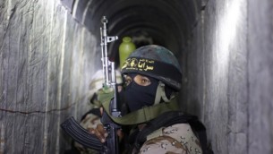مسلحون فلسطينيون من الذراع العسكري للجهاد الإسلامي، سرايا القدس، يسيرون في نفق يُستخدم لنقل صواريخ وقذائف ذهابا وإيابا إستعدادا للصراع القادم مع إسرائيل، خلال مشاركتهم في تدريبات عسكرية جنوبي قطاع غزة، 3 مارس، 2015. (AFP/Mahmud Hams)