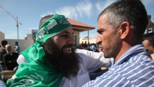 اسير من حركة حماس تم اطلاق سراحه ضمن صفقة شالين يعانق اقربائه في رام الله، 18 اكتوبر 2011 (Yossi Zamir/Flash90)