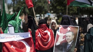 فلسطينيون داعمون لحركة حماس يحملون صور الرئيس التركي رجب طيب اردوغان بينما يهتفون عبارات ضد محاولة الانقلاب العسكري في تركيا، خلال مظاهرة في غزة، 17 يوليو 2016 (AFP/MAHMUD HAMS)