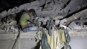 معروف، طفل يبغ 12 عاما ينتظر الانقاذ من بين الركام بعد غارة جوية في حي القطارجي في حلب، 16 اكتوبر 2016 (AFP PHOTO/THAER MOHAMMED)