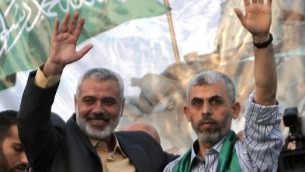 قائد حماس حينذاك إسماعيل هنية (من اليسار) والأسير الفلسطيني المرر يحيى السنوار، مؤسس الجناح العسكري للحركة، خلال إحتفال في إطلاق سراح مئات الأسرى الفلسطينيين في إطار اتفاق غلعاد شاليط، في خام يونس، جنوب غزة في 21 أكتوبر، 2011. (AFP/Said Khatib)