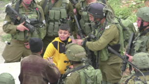 طفل فلسطيني يقوده جنود في انحاء مدينة الخليل في الضفة الغربية، 21 مارس 2017 (Screen capture: B’Tselem)
