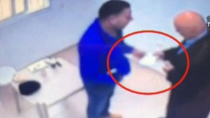 تصوير كاميرات مراقبة تظهر عضو الكنيست باسل غطاس يقدم مغلف لأسير امني فلسطيني داخل سجن اسرائيلي (Screen capture: Channel 10)
