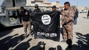 جنود عراقيون يحملون علم تنظيم الدولة الإسلامية معكوس في ضواحي الموصل، 23 نوفمبر 2016 (AFP/Thomas Coex)
