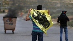 متظاهر فلسطيني يحمل علم عليه صورة مروان البرغوثي خلال مظاهرة في الضفة الغربية، 23 ابريل 2017 (AFP Photo/Abbas Momani)