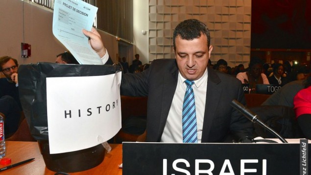 سفير إسرائيل لدى اليونسكو كرمل شاما هكوهين يلقي بنسهة من قرار حول القدس في سلة مهملات، 26 أكتوبر، 2016. (Erez Lichtfeld) 