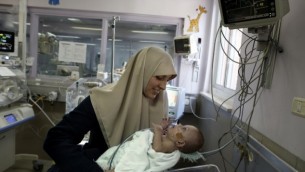 جمانة داوود من غزة تحمل ابنتها مريم البالغة من العمر 7 أشهر في مستشفى مقاصد في القدس الشرقية في 20 فبراير 2017، لأنها تجتمع بها لأول مرة منذ ولادة الطفلة المبكرة. (AFP/AHMAD GHARABLI).