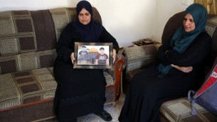 والدة اسامة عطا تحمل صورته في منزل العائلة في بلدة مير ابو مشعل في الضفة الغربية، 17 يونيو 2017 (AFP PHOTO / ABBAS MOMANI)
