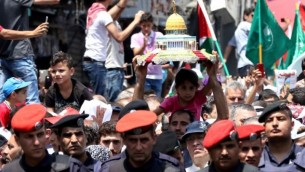 يحمل الأردنيون نموذجا لقبة الصخرة خلال مظاهرة دعت إليها جبهة العمل الإسلامي في عمان بعد صلاة الجمعة في 21 يوليو / تموز 2017 احتجاجا على الإجراءات الأمنية الإسرائيلية الجديدة التي نفذت في الحرم القدسي والتي تشمل البوابات الالكترونية، وكاميرات، عقب هجوم أسفر عن مقتل شرطيين إسرائيليين في الأسبوع السابق. (AFP/Khalil Mazraawi