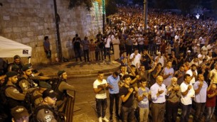 قوات الأمن الإسرائيلية تقف إلى جانب المصلين المسلمين الفلسطينيين خارج بوابة الأسباط، وهي نقطة وصول رئيسية إلى الحرم القدسي في البلدة القديمة في القدس، 24 يوليو / تموز 2017. (AFP/Ahmad GHARABLI)