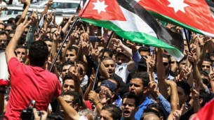 يحتج المتظاهرون الأردنيون خلال مظاهرة بالقرب من السفارة الإسرائيلية في العاصمة عمان في 28 يوليو / تموز 2017، رافعين الأعلام الوطنية ويهتفون بالشعارات, مطالبون بإغلاق السفارة وطرد السفيرة وإلغاء معاهدة السلام عام 1994 مع إسرائيل. (AFP PHOTO / KHALIL MAZRAAWI) 