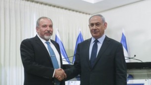 رئيس الوزراء بنيامين نتنياهو (يمين) وزعيم حزب يسرائيل بيتينو أفيغدور ليبرمان يتصافحان بعد توقيع اتفاق الائتلاف في الكنيست يوم الأربعاء 25 مايو 2016. (Yonatan Sindel/Flash90)