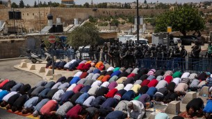 مصلون مسلمون يصلون امام عناصر الشرطة الإسرائيلية في حي راس العامود في القدس الشرقية، 28 يوليو، 2017. (Hadas Parush/Flash90)