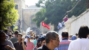 مصلين مسلمين عند بوابة الأسباط الذين رفضوا دخول الحرم القدسي في 27 يوليو 2017، حتى بعد أن بدأ الآلاف في الوصول الى الموقع المقدس. واحد المتظاهرين يحمل العلم التركي. (Dov Lieber / Times of Israel)