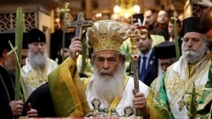 البطريرك الأرثوذكسي اليوناني ثيوفيلوس الثالث (وسط الصورة) يترأس قداس أحد الشعانين في كنيسة القيامة في المدينة القديمة في القدس، 9 أبريل، 2017. (AFP Photo/Gali Tibbon)