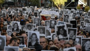 اشخاص يحملون صور ضحايا التفجير في مركز اميا ال85 في الذكرى ال22 للهجوم، 18 يوليو 2016 (Leonardo Kremenchuzky, courtesy of AMIA/Via JTA)