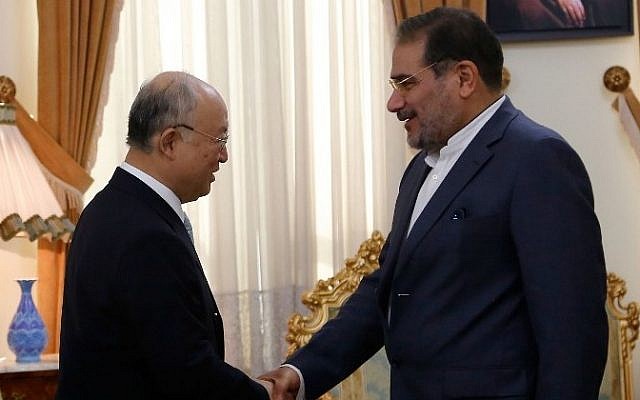 الأيمن العام للمجلس الأعلى للأمن القومي الإيراني، علي شمخاني، من اليمين، يصافح رئيس الوكالة الدولية للطاقة الذرية يوكيا أمانو خلال لقاء جمعهما في طهران، 2 يوليو، 2015. (AFP/ATTA KENARE) 