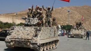 جنود لبنانيون يجلسون على حاملة جنود مدرعة في بلدة راس بعلبك شرقي البلاد، في 21 أغسطس، 2017، بعد العودة من القتال ضد تنظيم ’داعش’. (AFP Photo/Stringer) 