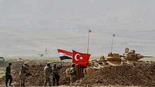 جنود يقفون بالقرب من دبابات تحمل الأعلام التركية والعراقية خلال تمرين عسكري مشترك بالقرب من الحدود التركية-العرقية بالقرب من منطقة سيلوبي التابعة لمحافظة شرناق، 26 سبتمبر، 2017. (AFP Photo/Ilyas Akengin) 