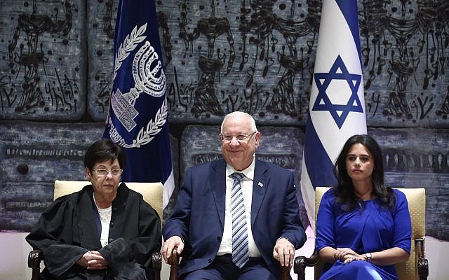 رئيس الدولة رؤوفين ريفلين ووزيرة العدل أييليت شاكيد يجلسان إلى جانب رئيسة المحكمة العليا المنتهية ولايتها ميريام ناؤور خلال مراسم أداء اليمين القانونية لرئيسة المحكمة الجديدة إستر حايوت في مقر إقامة رئيس الدولة في القدس، 26 أكتوبر، 2017. (Miriam Alster/Flash90) 