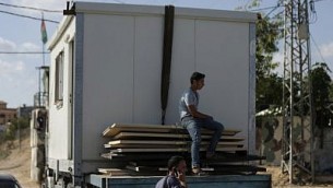 رجال فلسطينيون يقومون بتفكيك مبنى لحركة ’حماس’ في المدخل الشمالي لقطاع غزة القريب من معبر ’إيريز’ الذي تسيطر عليه إسرائيل، 1 نوفمبر، 2017، في بيت حانون. (SAID KHATIB / AFP)
