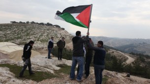 ناشطون فلسطينيون يرفعون العلم الفلسطيني في منطقة اي 1، شرقي القدس (Issam Rimawi/Flash90)