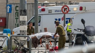 جنود يخلون جثمان رجل فلسطيني حاول طعن جنود في حاجز قلنديا، 27 ابريل 2016 (Yonatan Sindel/Flash90)