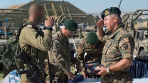 جندي قبرصي يحيي جندي اسرائيلي خلال تدريب عسكري في قبرص، يونيو 2017 (IDF Spokesperson’s Unit)