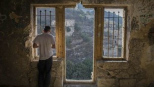 رجل يهودي متشدد يصلي في مبنى في قرية ليفتا الواقعة عدة مدخل القدس (Yonatan Sindel/Flash90)