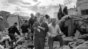 Firemen and civilians walks over the rubble left a