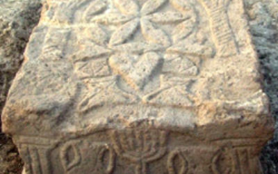 A stone engraved with a menorah from a Second Temple period synagogue was excavated at Migdal in Israel. Photo: Isranet