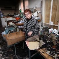 A victim of the Federal government's ceiling insulation scheme. Edith Preston collect a few items from her burnt out home. photo: peter haskin