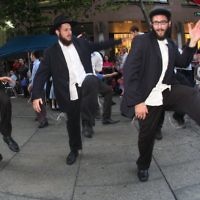 Yeshiva student (from left) Ellie Sellim, Mendy Chesny and Chidah Levitansky dancing in Martin Place. PHOTO: Ingrid Shakenovsky