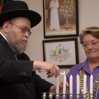 Rabbi Pinchus Feldman lights the Chanukah candle with Waverley mayor Sally Betts.