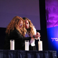 14-4-13. Yom Ha Zikaron at Robert Blackwood Hall, Monash University. Denise Waxman and her daughter Gabby light  a candle for their relative Nachman Mordeci Wachsman.  Photo: Peter Haskin