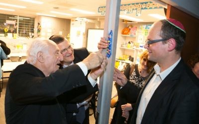 From left: Aron Kleinlehrer, Shmuel Ben-Shmuel, Tracey Waxman and Adam Carpenter, head of Jewish life (primary), affix a mezuzah made by students to the doorpost of a new classroom. Photo: Ofer Levy