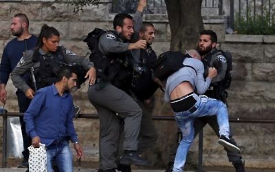 Border Police officers scuffle with a Palestinian protester as they detain him near Damascus Gate outside Jerusalem's Old City.