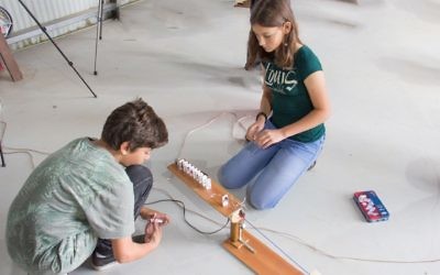 Students Jamie Sobol (left) and Alexandra Patishman hard at work on their machine.
