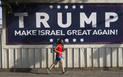 An Israeli jogger passes a pro-Trump placard in Tel Aviv. Photo: EPA/Jim Hollander