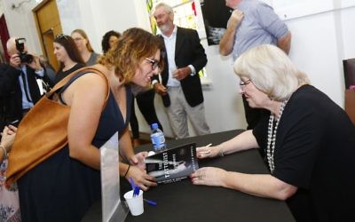 Author Heather Morris signs a copy of The Tattooist of Auschwitz at the book lunch at the Jewish Holocaust Centre in Melbourne in February. Photo: Peter Haskin