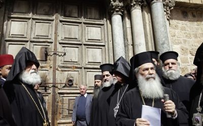 Theophilos III (second on right) stands outside the closed doors of the Church of the Holy Sepulchre during Sunday's protest. Photo: AP/Mahmoud Illean