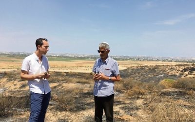 The AJN's Nathan Jeffay (left) with Eyal Hagbi on a patch of land scorched by a kite fire.